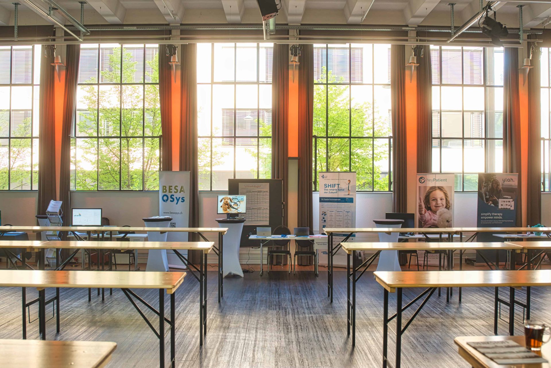 Lichtdurchfluteter Saal mit Stehtischen am Fenster