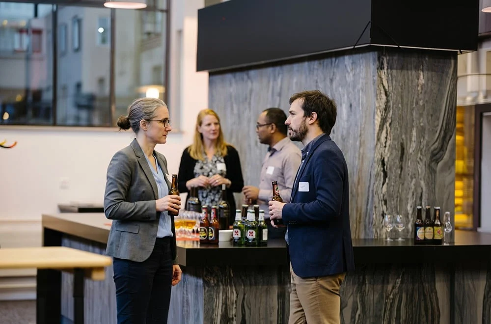 Gäste unterhalten sich beim Apéro an der Bar im Eventforum Bern.