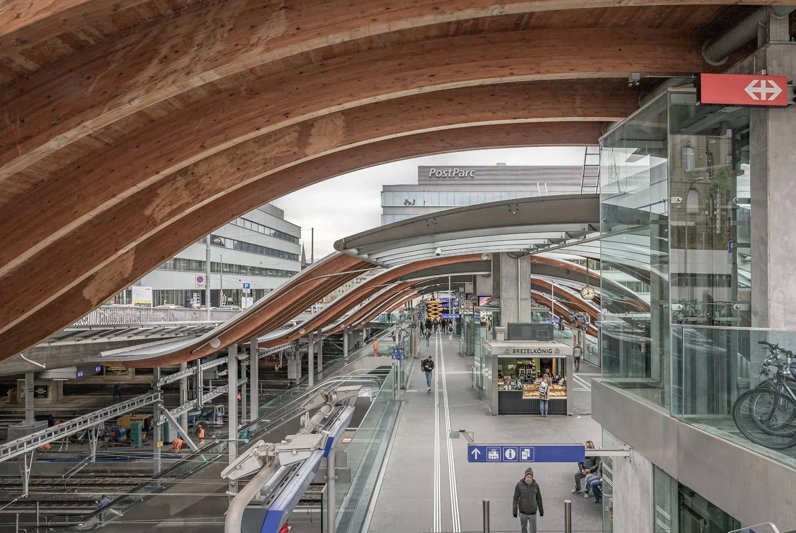 Blick auf Bahnhof Bern mit PostParc und überdachten Gleisen.