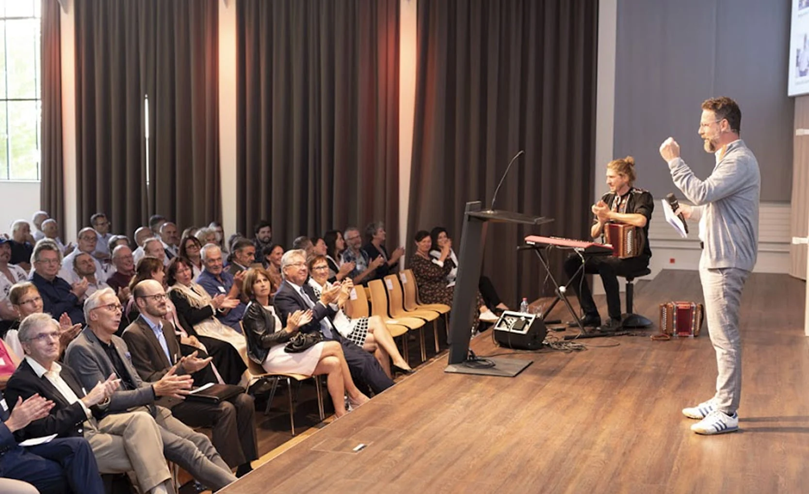 Bühnenauftritt mit Musik und Moderation vor Publikum im Eventforum Bern.