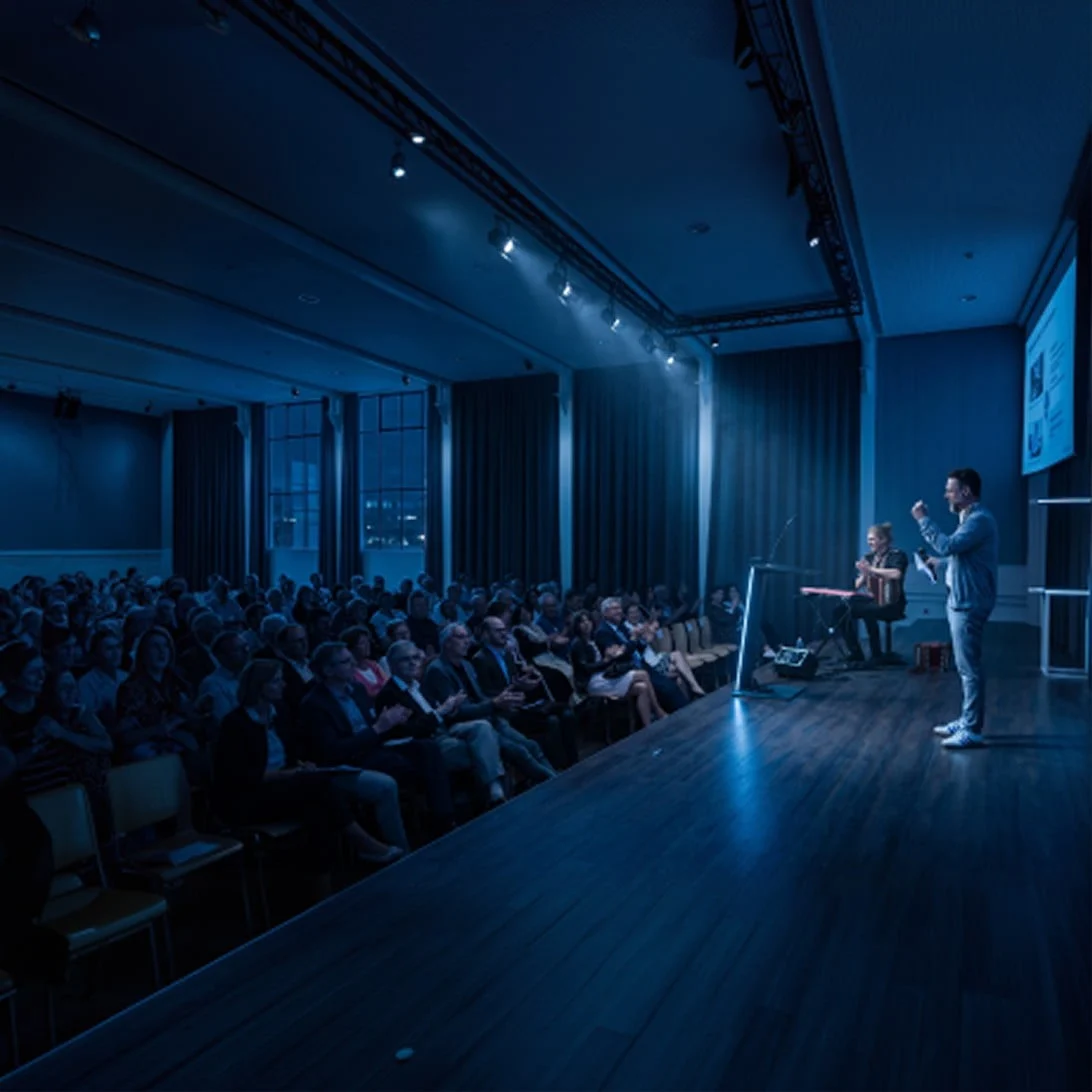 Bühnenpräsentation mit Musik und Moderation vor Publikum im Eventforum Bern.