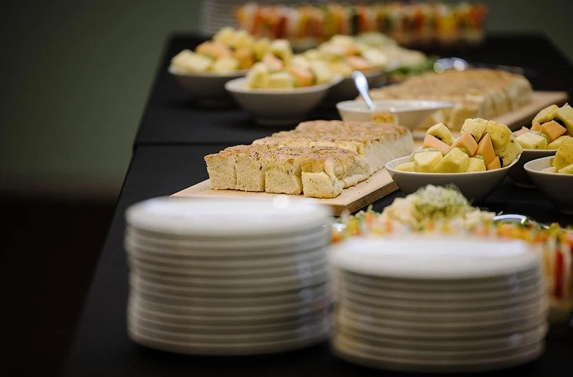 Catering-Buffet mit Fingerfood, Obstschalen und gestapelten Tellern für eine Veranstaltung im Eventforum Bern.