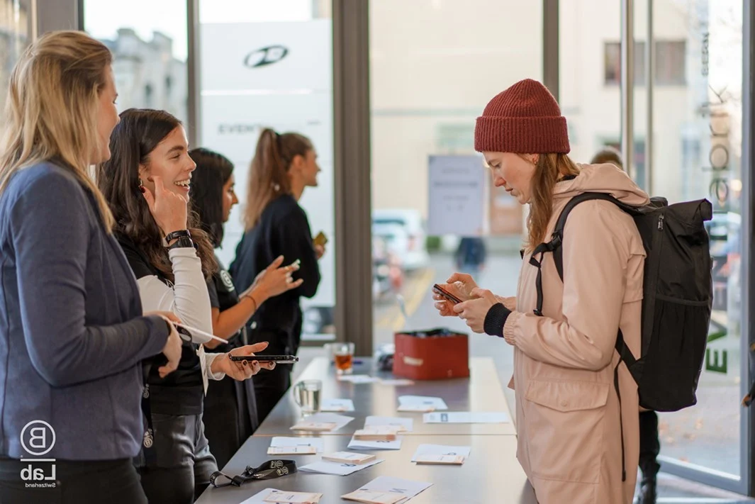 Teilnehmende beim Check-in am Empfang einer Veranstaltung im Eventforum Bern.
