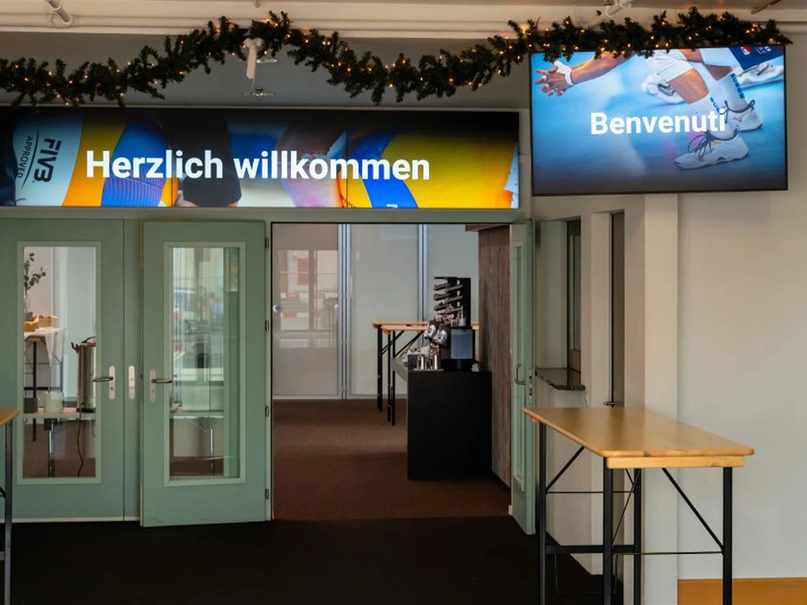 Videowall mit Willkommensgruss und Screen über dem Eingang des Eventforums Bern.