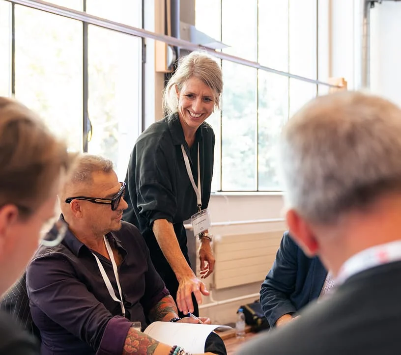 Teilnehmende besprechen Unterlagen bei einem Business Event im Eventforum Bern.