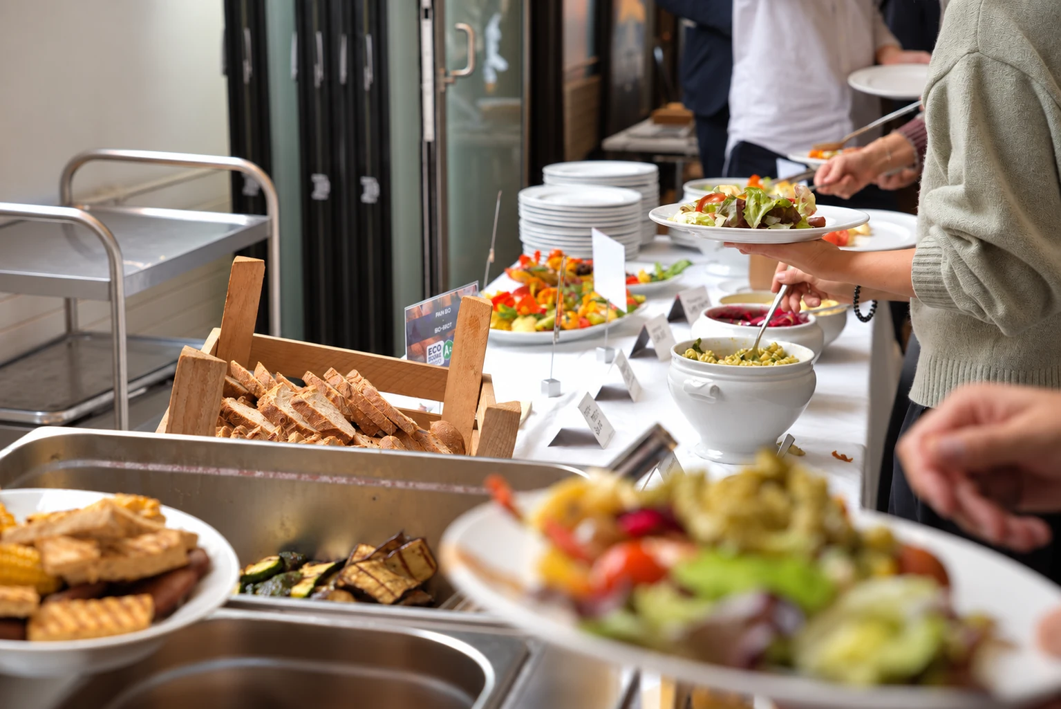 Les invités se servent au buffet du déjeuner d’affaires, avec salades, pain et plats chauds.