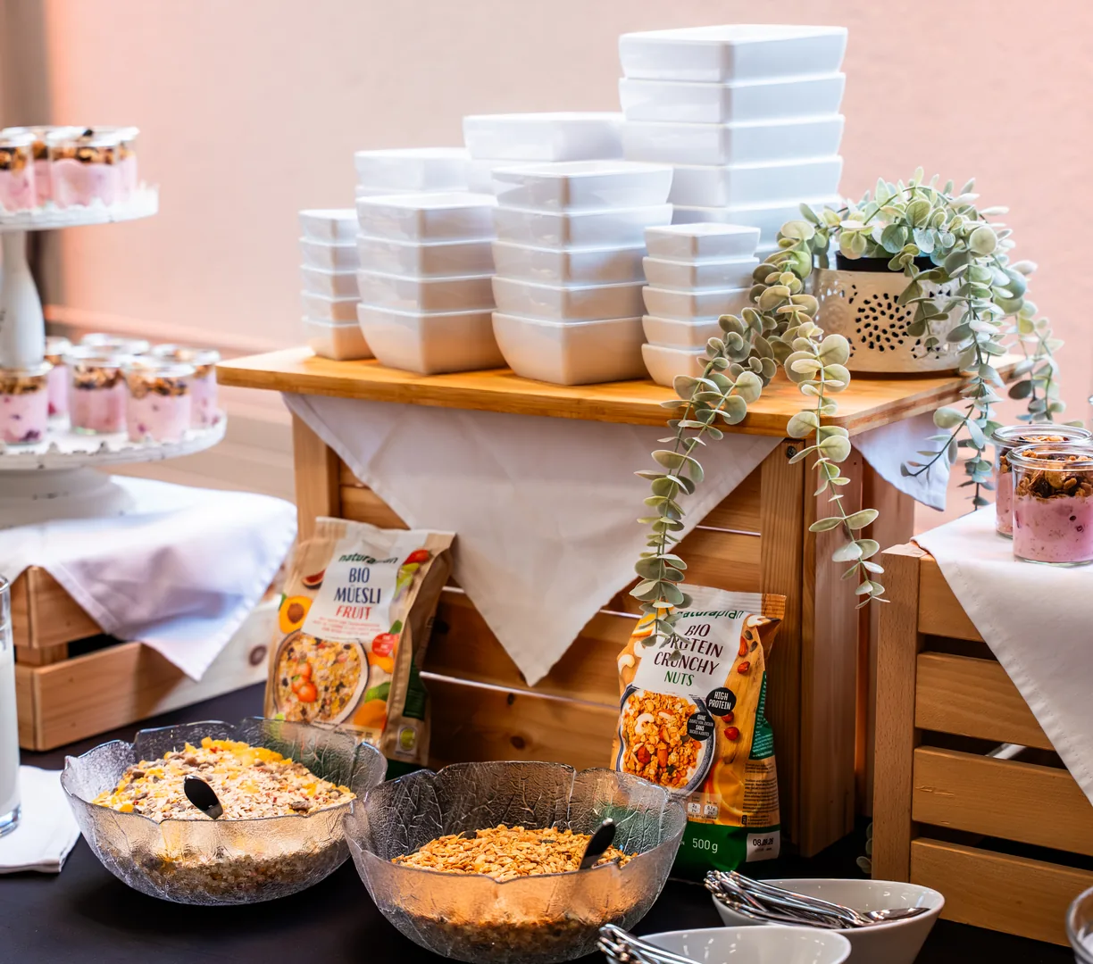 Frühstücksbuffet mit Joghurt, Müesli und Gebäck auf Holzkisten bei einem Anlass im Eventforum Bern.