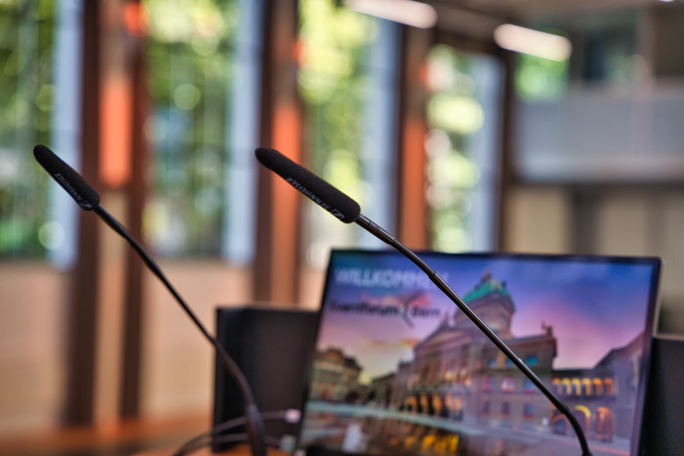Two lectern microphones in front of a presentation at Eventforum Bern.