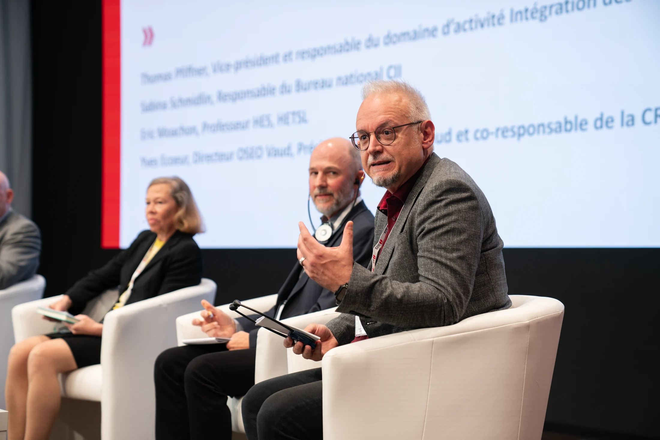 Panel discussion with microphones and attentive participants.