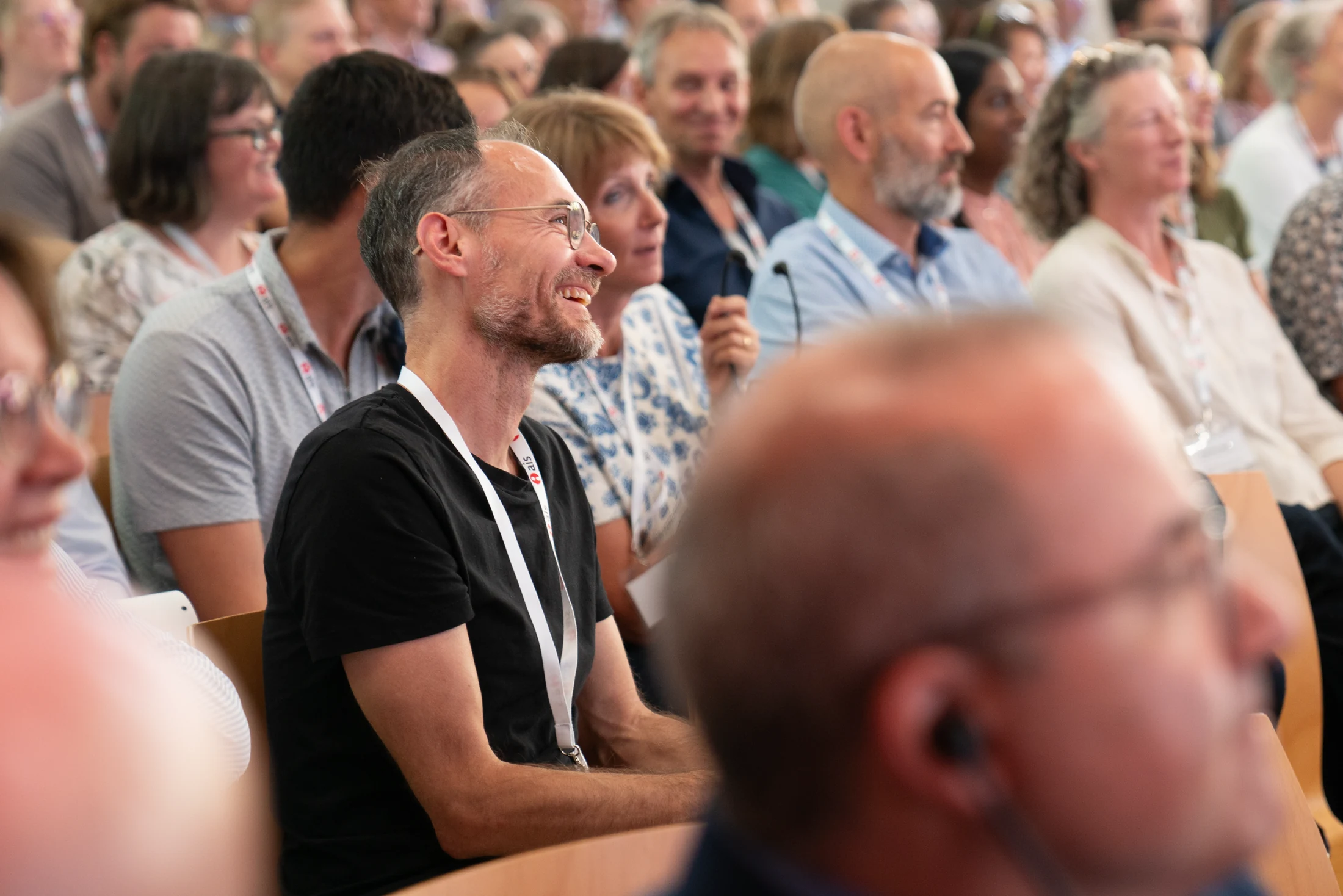 Aufmerksame Teilnehmende im hellen Saal des Eventforum Bern