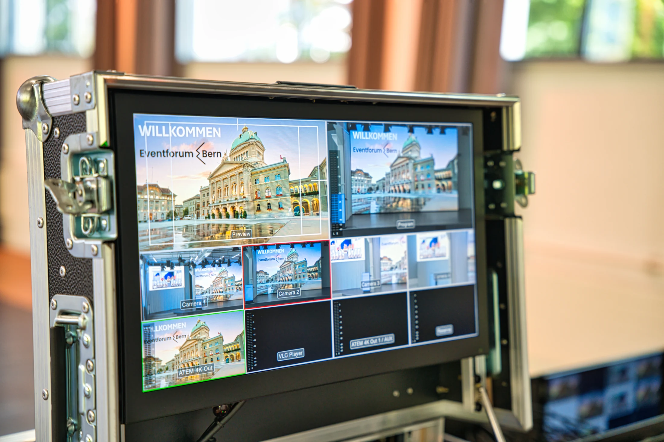 Professional video control desk with multiple camera views on the monitor.