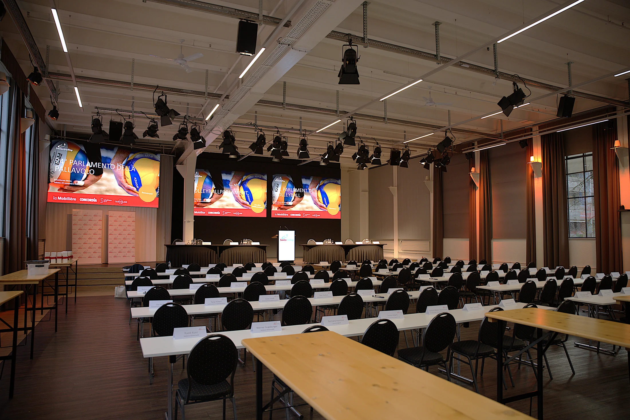 Plenarsaal mit Seminartischen und Präsentationswänden