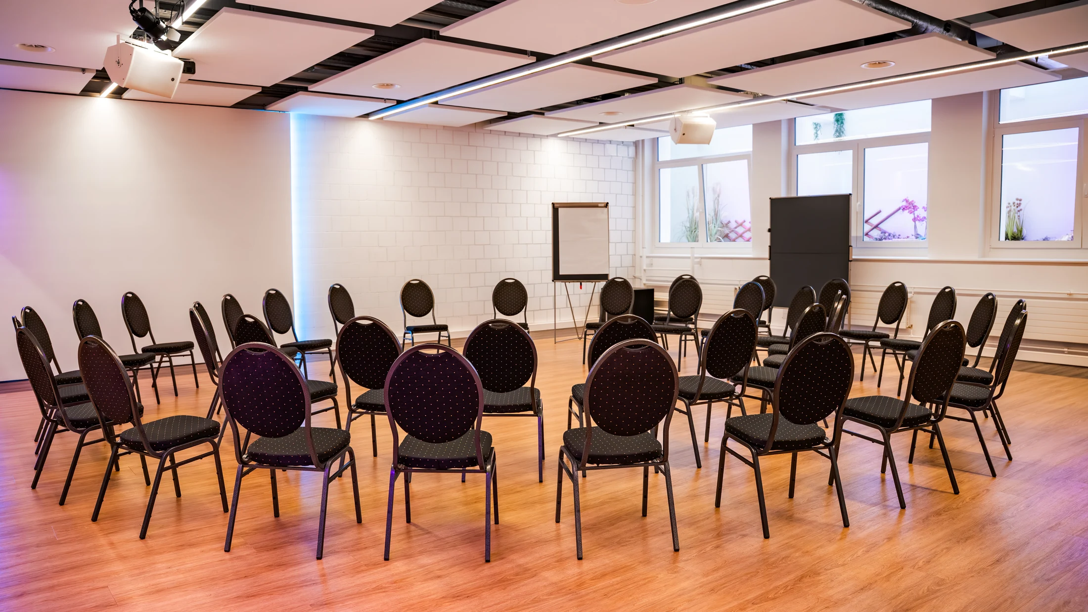 Workshopraum mit Stuhlkreis und Flipcharts