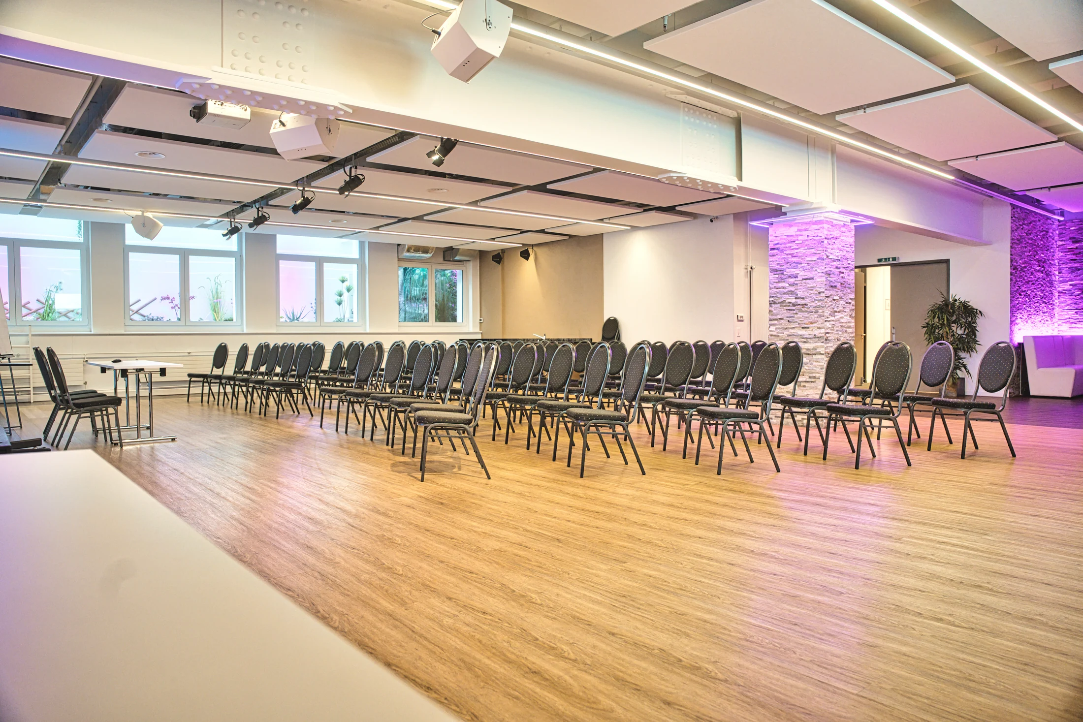 Bright workshop room with U-shaped tables and a presentation display.