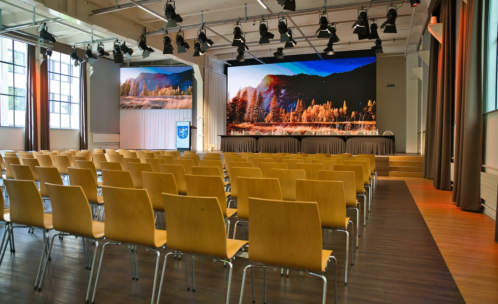 Eventhalle mit Reihenbestuhlung, Bühne und LED-Wänden im Eventforum Bern.