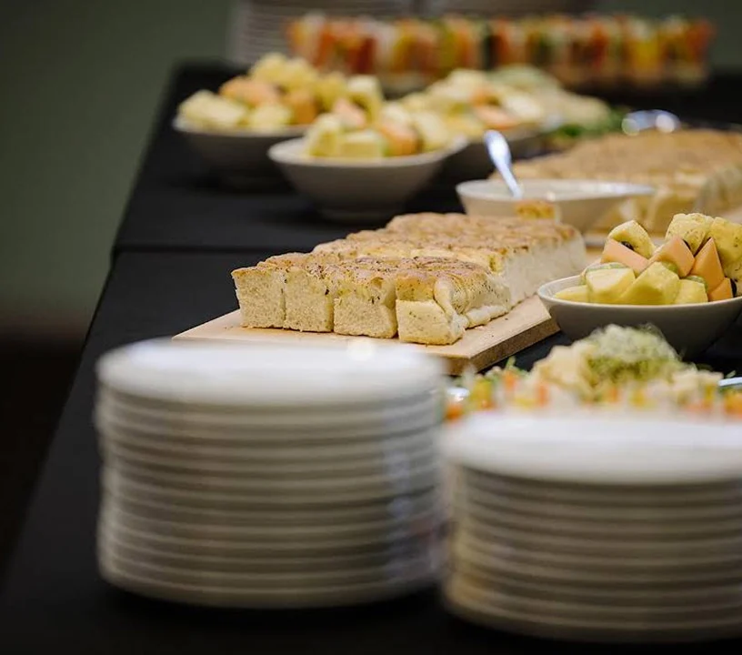 Buffet mit Fingerfood, Obstschalen und gestapelten Tellern für Flying Food.