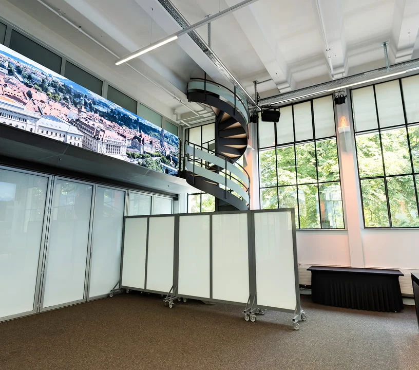 Foyer mit Glastrennwänden und Videowand für Networking im Eventforum Bern.