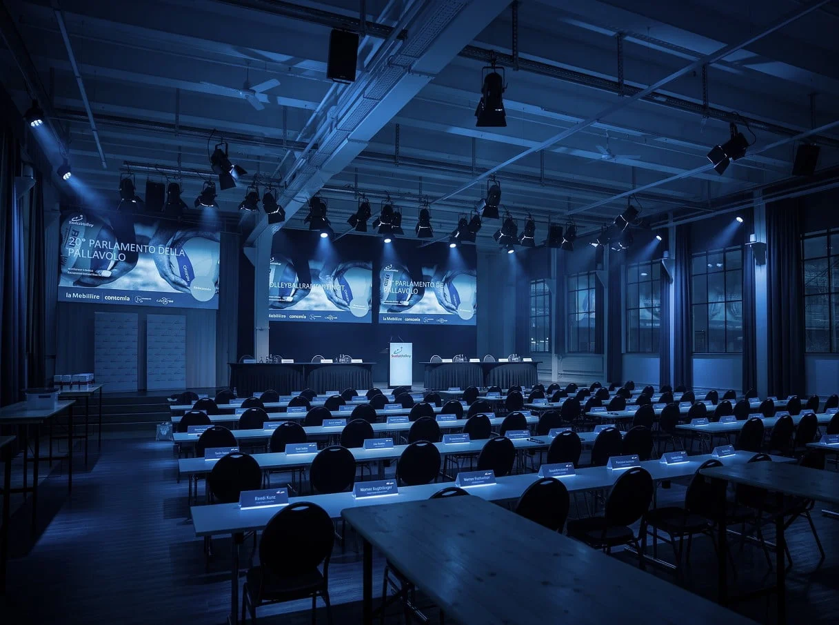 Conference hall with a stage, LED walls and classroom seating at Eventforum Bern.