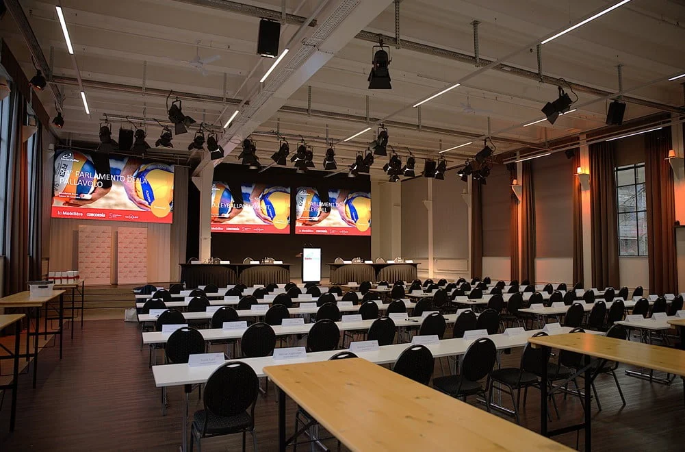 Konferenzsaal mit Bühne, Präsentationsflächen und Tischbestuhlung im Eventforum Bern.