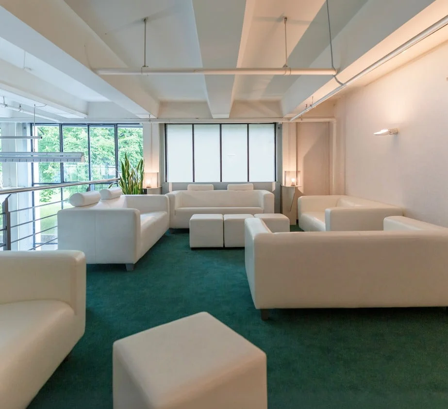 Lounge-Bereich mit weissen Sofas und Sesseln im Eventforum Bern.