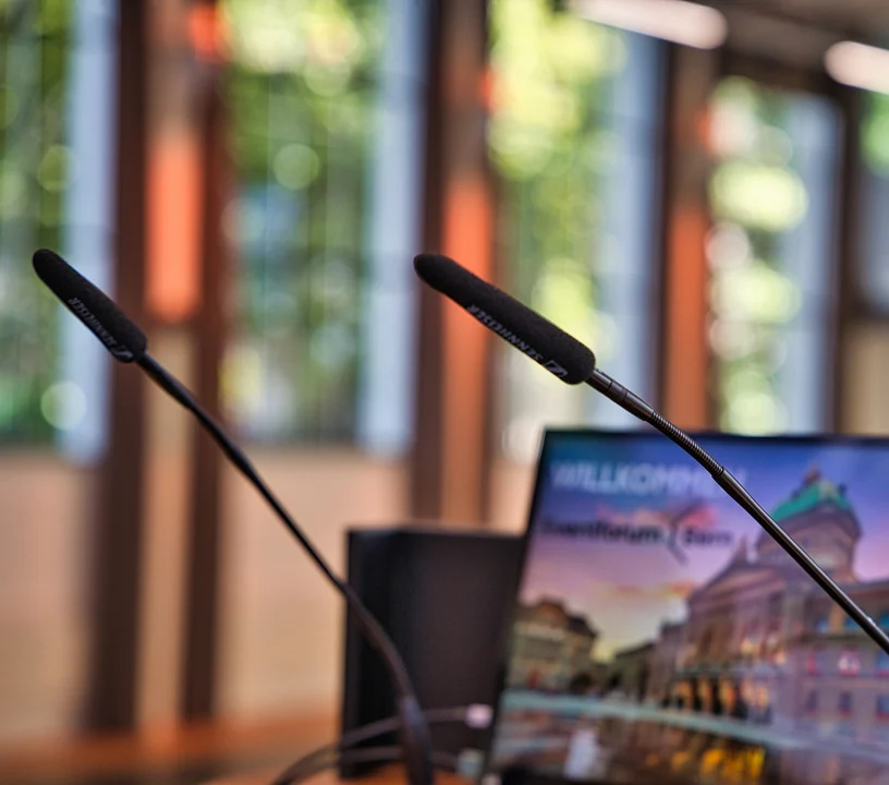 Mikrofone vor Präsentationsbildschirm für Beschallung und Mikrofonie im Eventforum Bern.