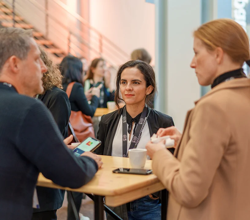 Teilnehmende unterhalten sich beim Networking an einem Stehtisch im Eventforum Bern.