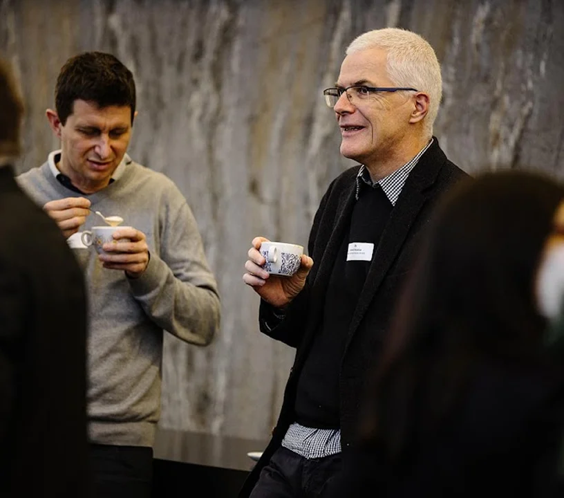Teilnehmende mit Kaffee während einer Pause bei einer Veranstaltung.
