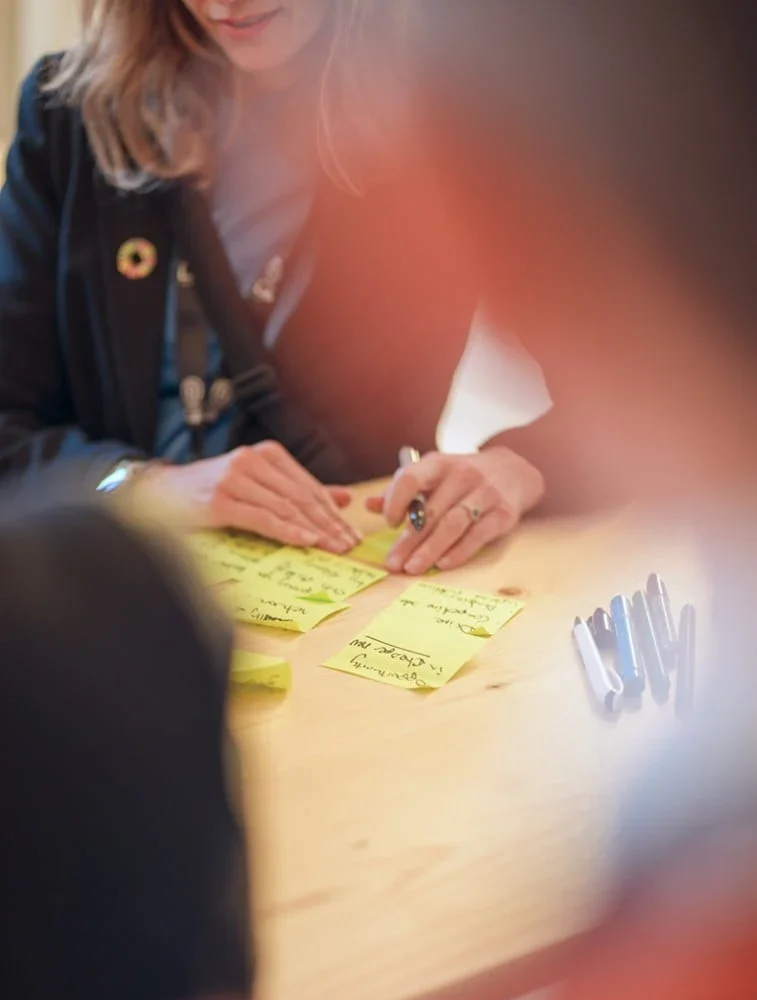Person schreibt Haftnotizen während eines Workshops im Eventforum Bern