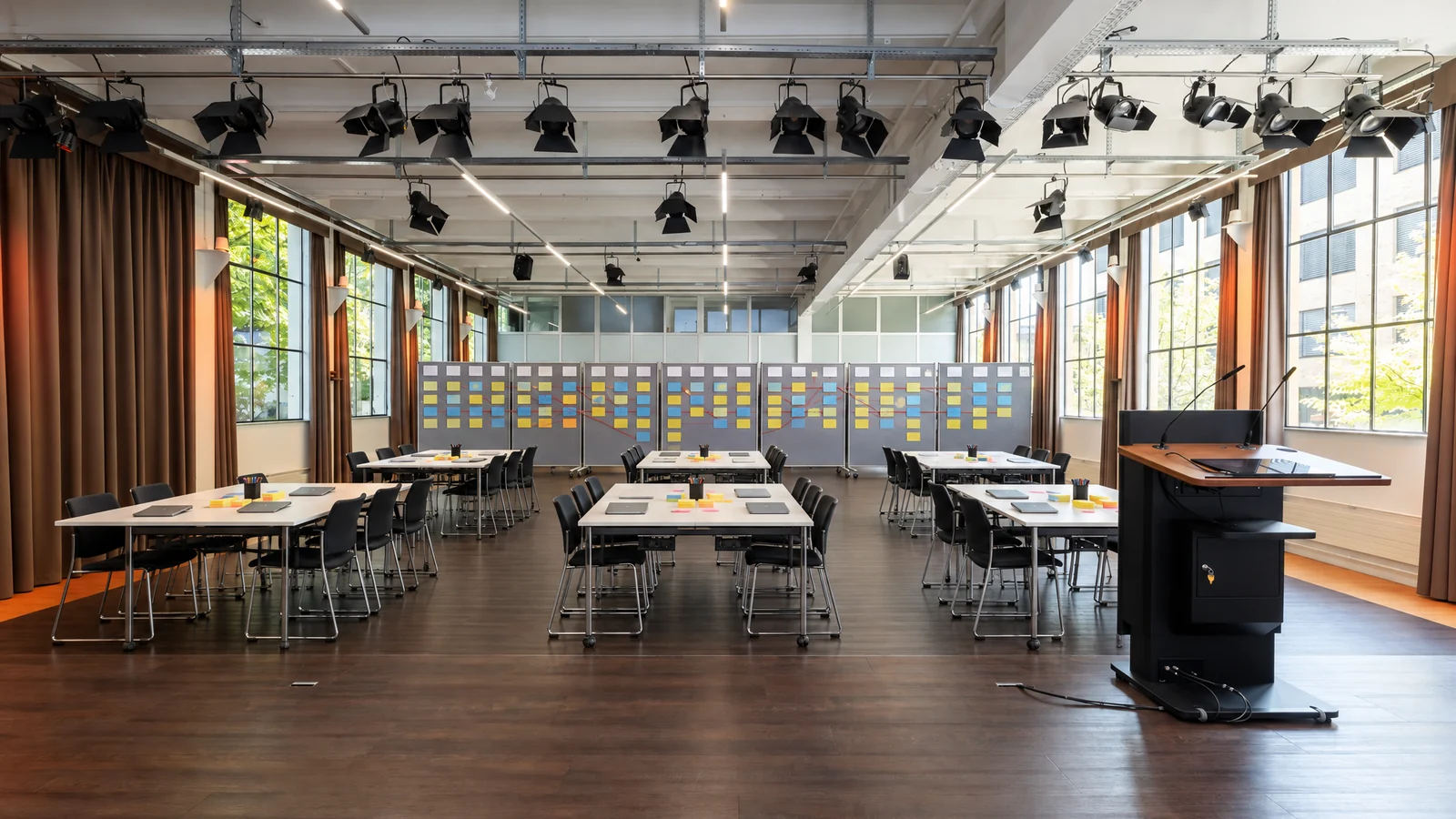 Fotomontage: Eventhalle von der Bühne aus, Teamtische und Board-Wand an der Rückwand im Eventforum Bern