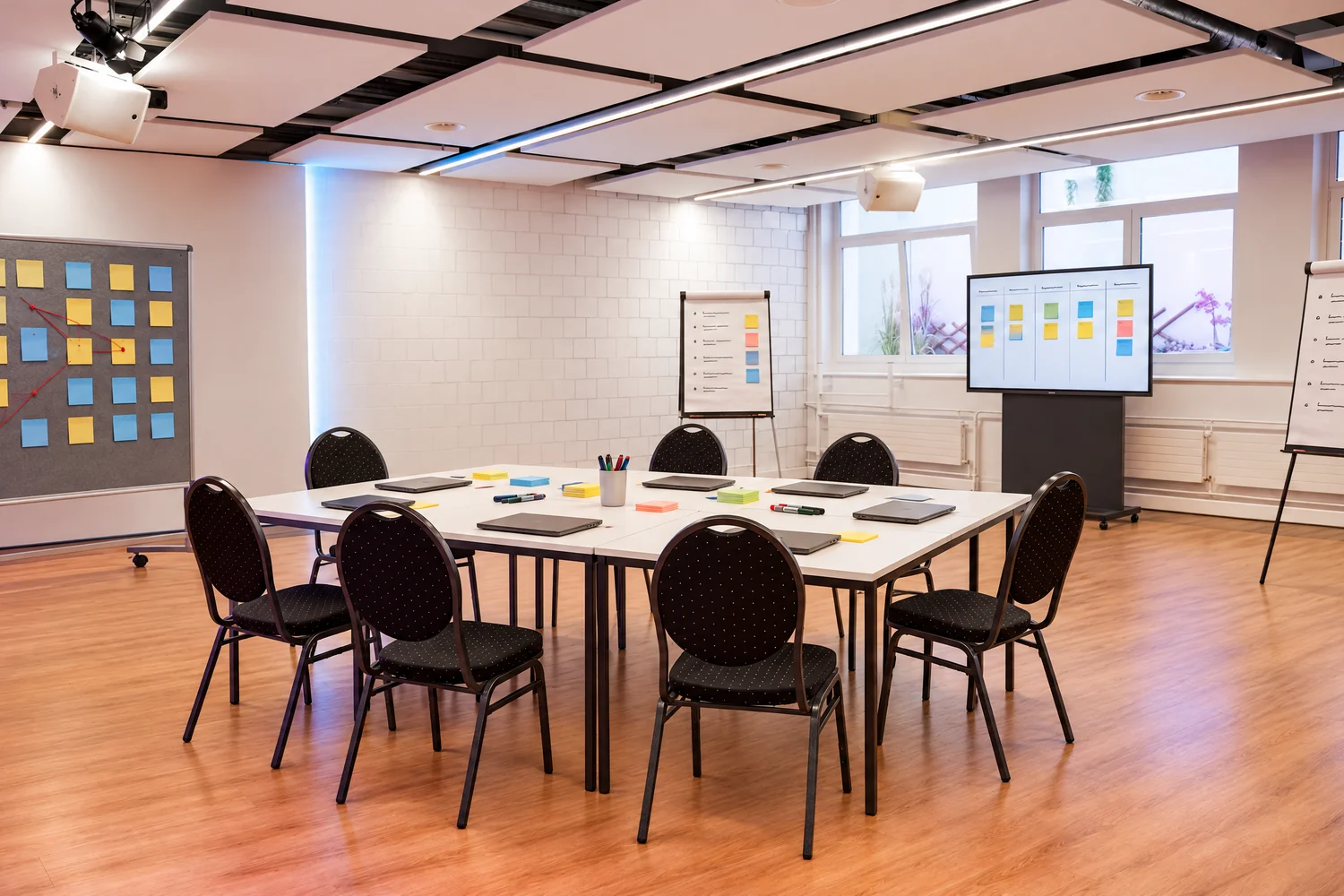 Fotomontage: Workshopraum als Breakout eines Teams mit Board-Bildschirm, Pinnwand und Flipcharts im Eventforum Bern