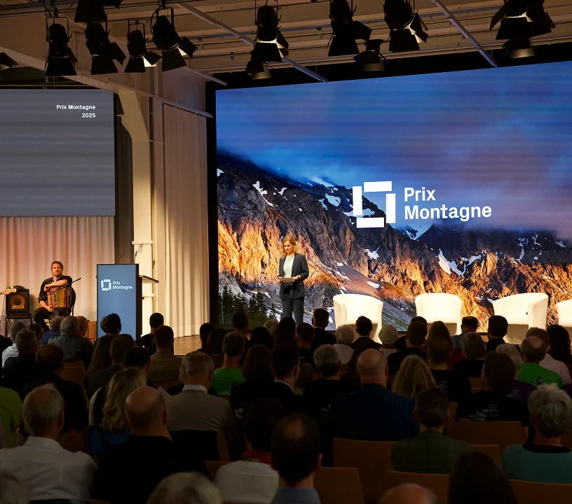 Plenarsaal des Eventforums Bern mit grosser LED-Wand und bestuhltem Publikum.