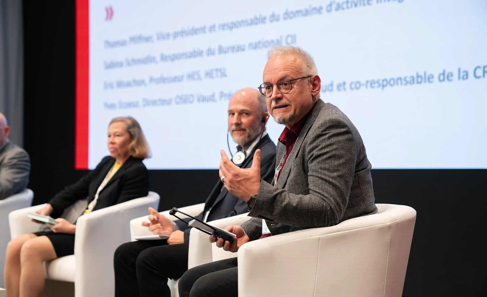 Podiumsteilnehmender spricht mit Mikrofon während einer Diskussion im Eventforum Bern.