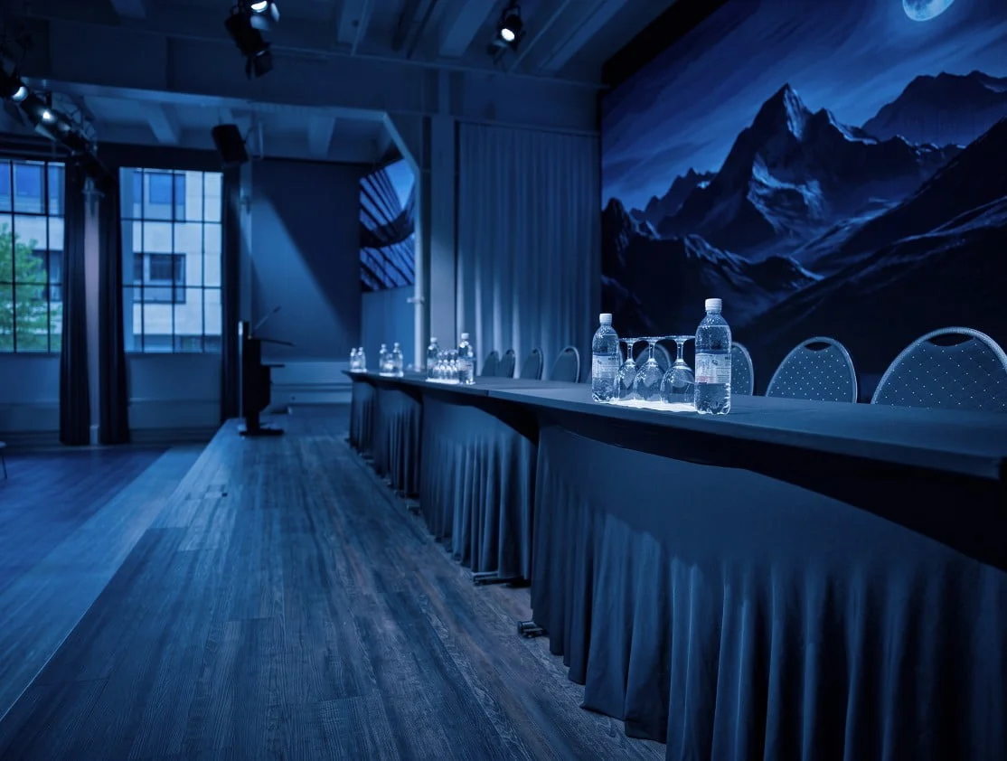 Panel table with water bottles and glasses in front of an LED wall at Eventforum Bern.