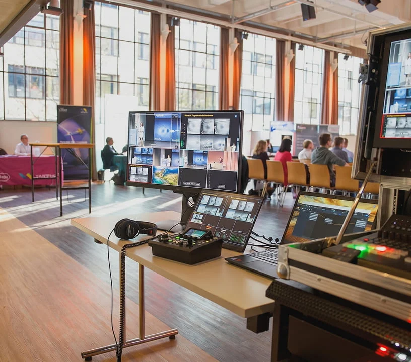 Regiepult mit Monitoren und Mischpult im hellen Schulungsraum des Eventforums Bern.
