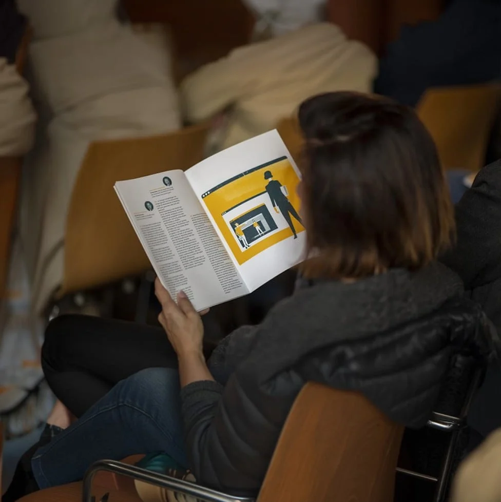 Teilnehmerin liest Veranstaltungsunterlagen während einer Veranstaltung im Eventforum Bern.