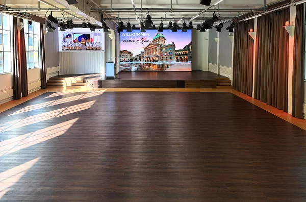 Leerer Veranstaltungsraum mit Bühne, LED-Wand und Lichttechnik im Eventforum Bern.