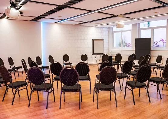 Workshopraum mit Stuhlkreis, Flipchart und Präsentationsfläche.